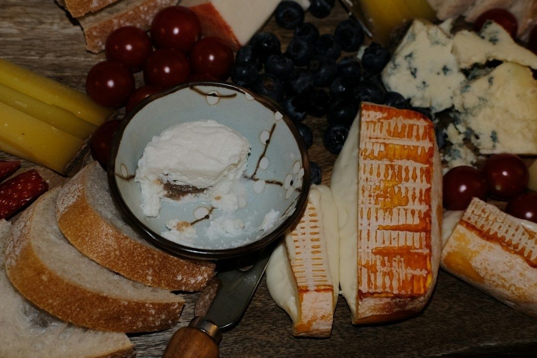Ostbricka med olika ostar, bröd, blåbär och vindruvor
